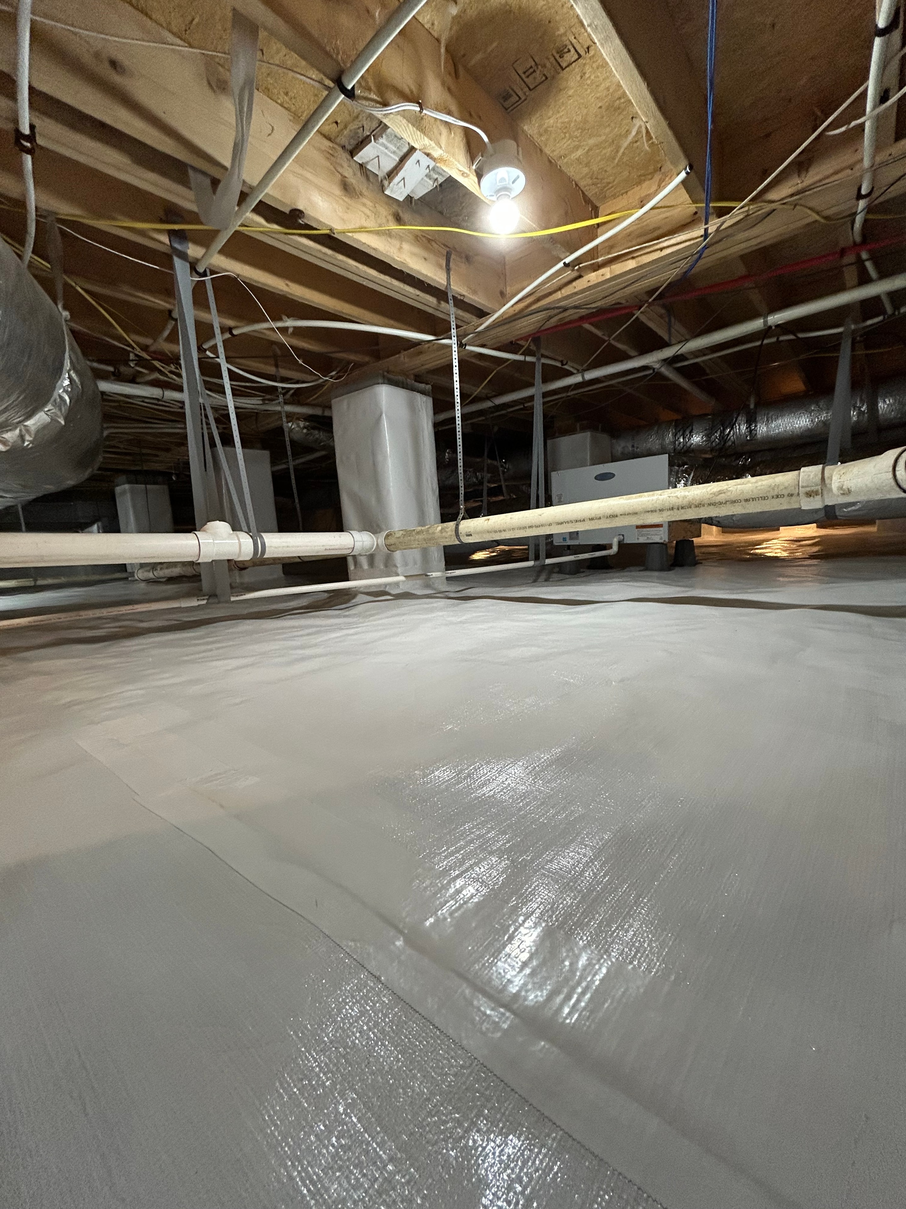 Crawl space with pipes and vapor barrier