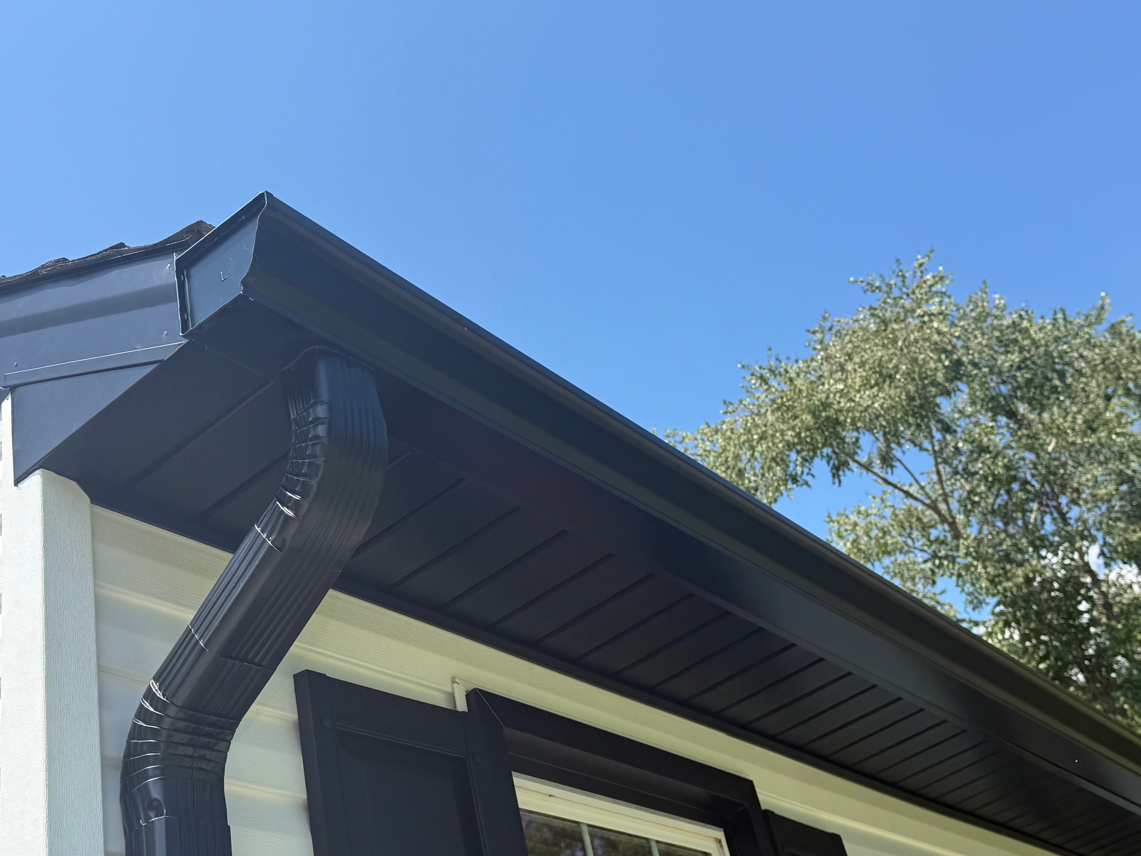 Seamless black gutters and downspout on home exterior